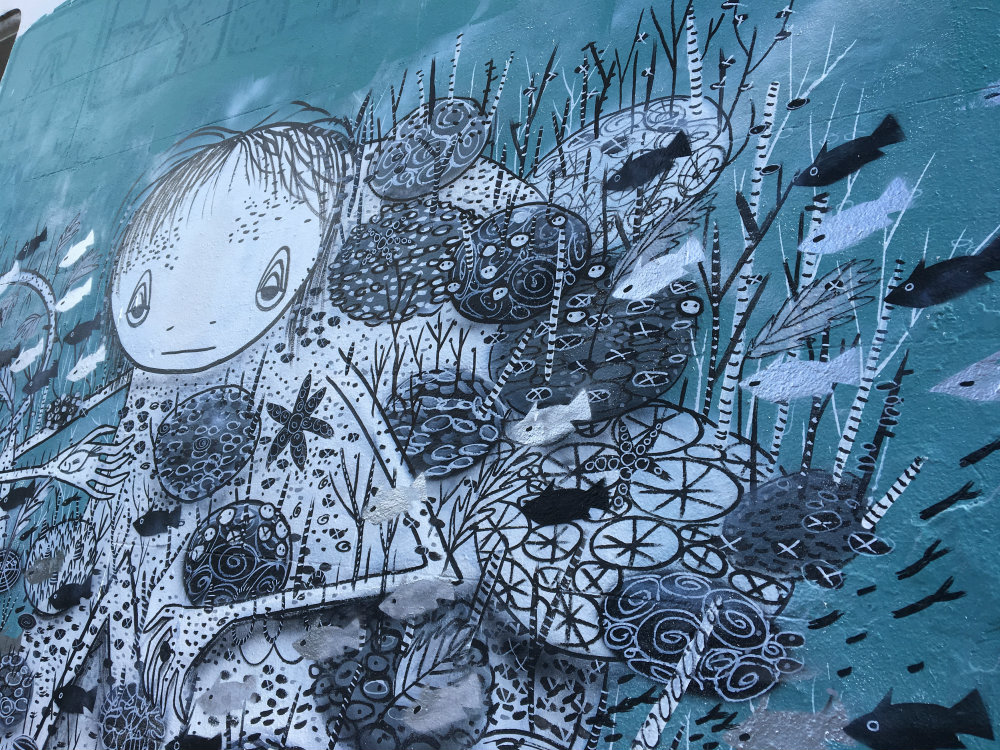 graffiti drawing of girl in the blue sea with fish