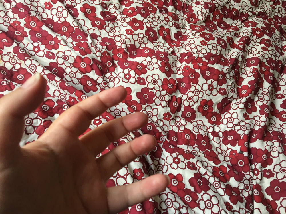 fingers and hands that are real, living, breathing objects with red clean bed linen