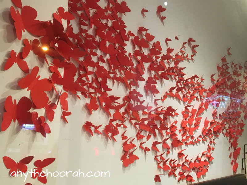red paper butterflies flooding across a wall in collingwood