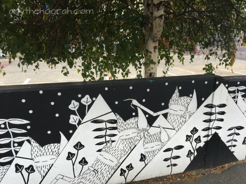 black and white graphical street art and greenery