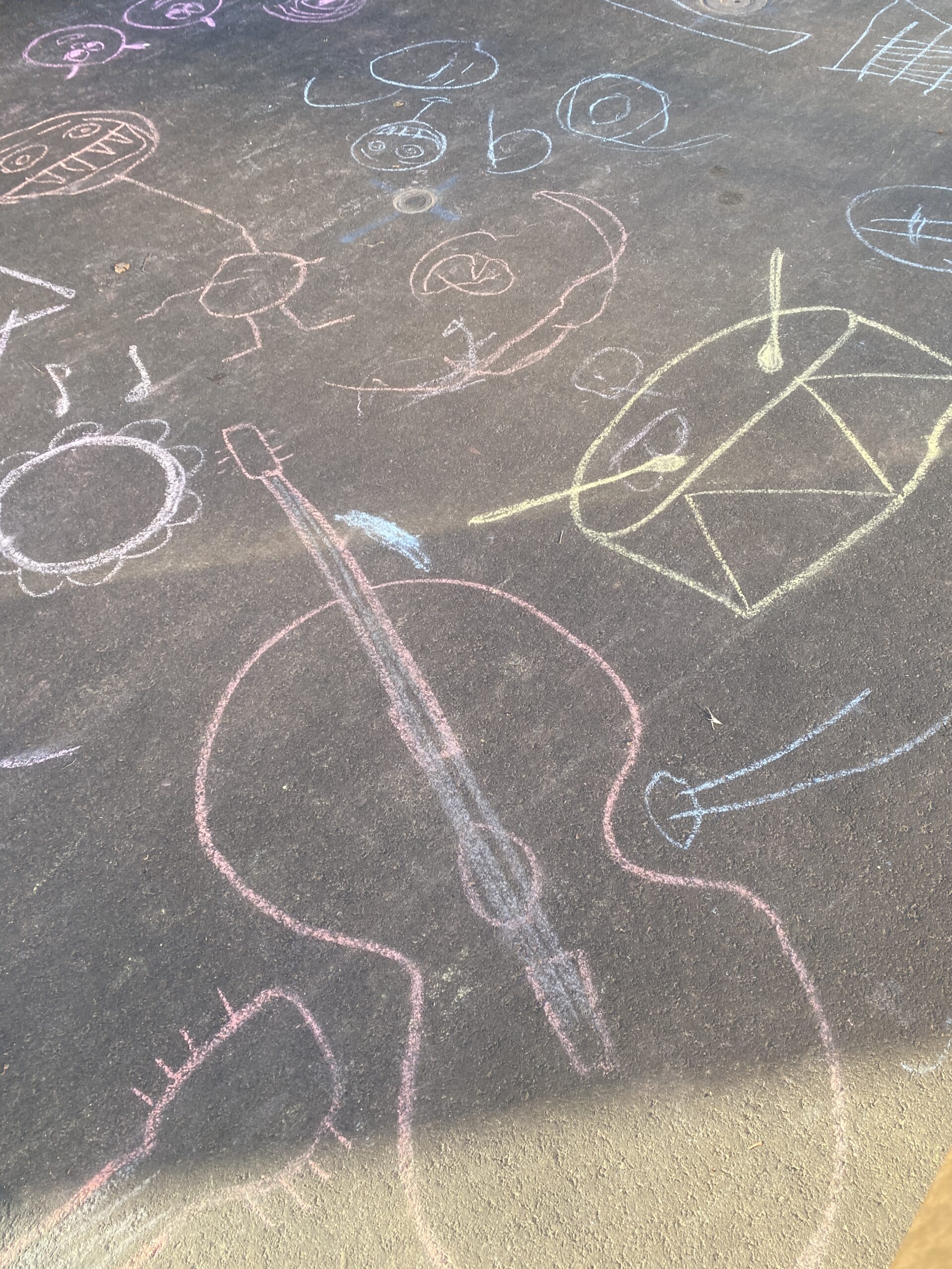 chalk drawings of musical instruments on the pavement outside a shop in fitzroy VIC 3065