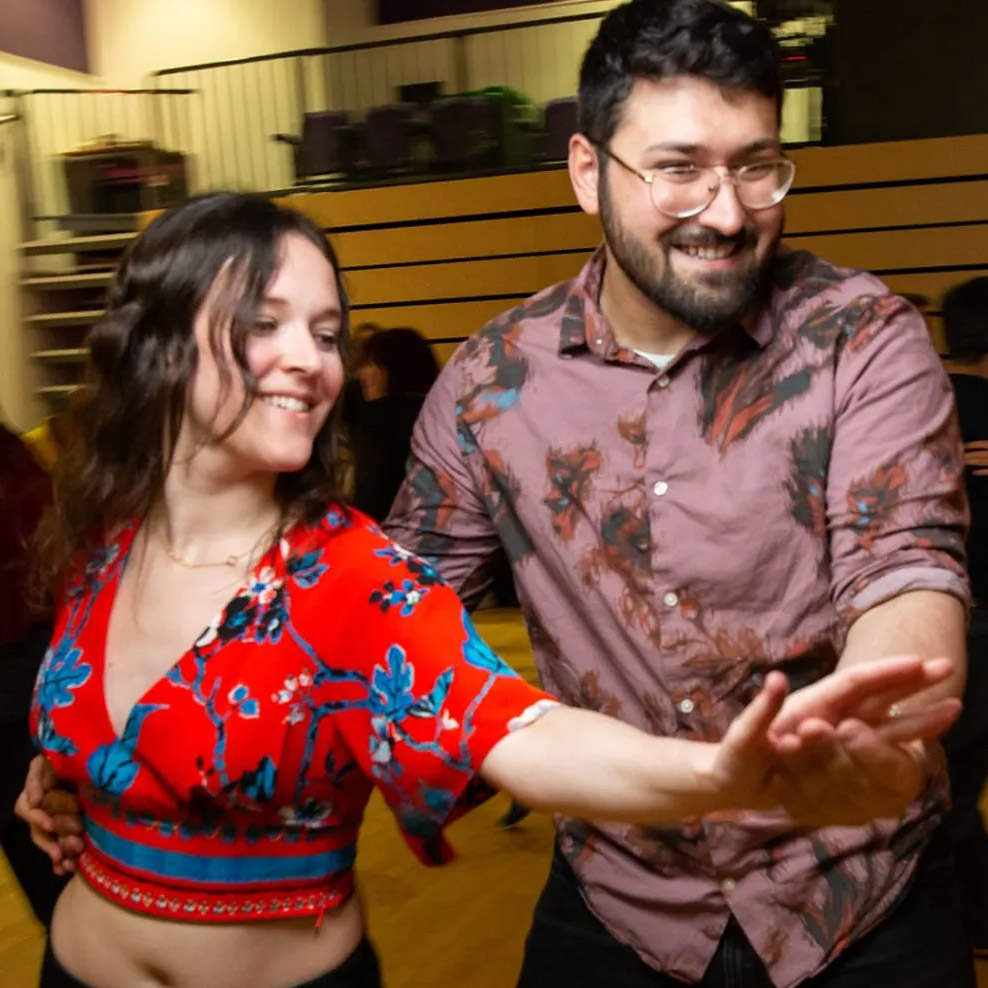 couple salsa dancing in red and plum